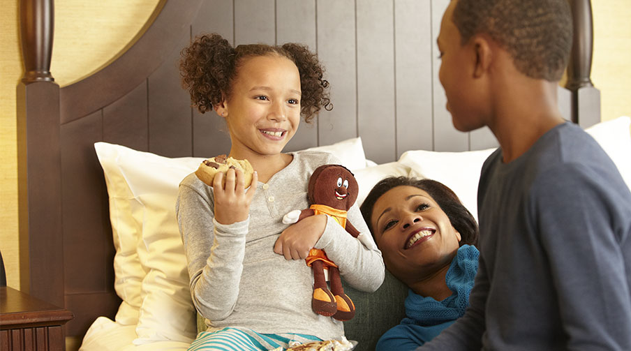 Mother with two small kids eating cookies in hotel room.