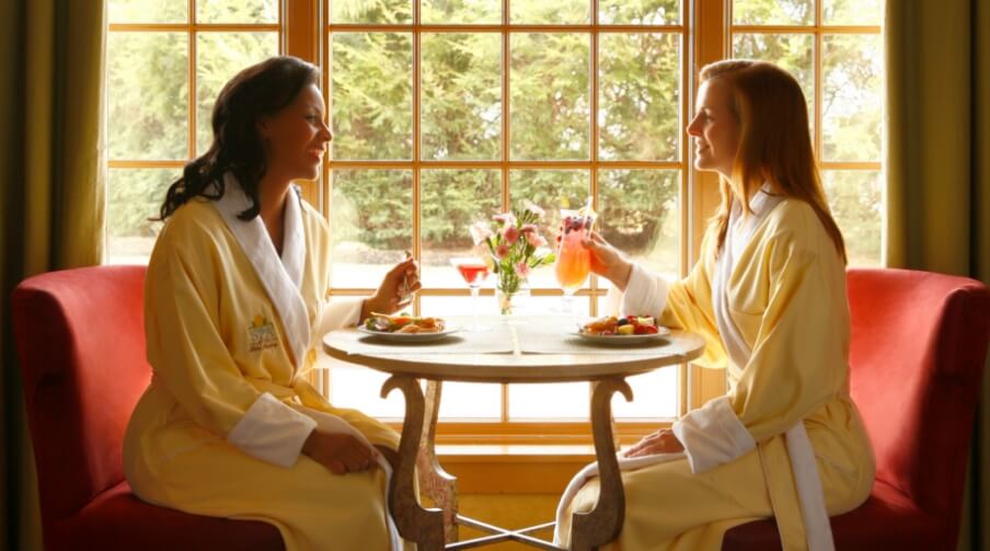 Two women sitting in robes eating lunch at The Hotel Hershey.